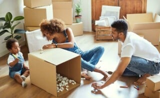 family of three moving with boxes