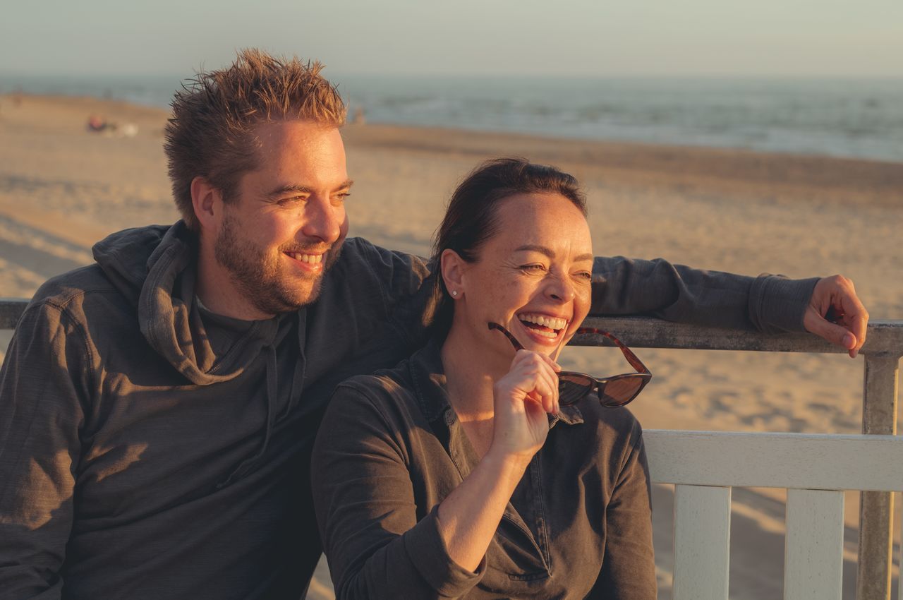 Dries and Vanessa laughing while looking at a beautiful sunset.