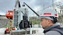 Director Zebediah Smith with Open Jaw Productions monitors a video feed Nov. 2, 2021 of U.S. Army Corps of Engineers Nashville District Electricians Ron Gatlin and Kyle Mosakowski working in the switch yard at Center Hill Dam in Lancaster, Tennessee, for a National Inventory of Dams video production. The Nashville District operates and maintains the project on the Caney Fork River in Lancaster, Tennessee. (USACE Photo by Lee Roberts)