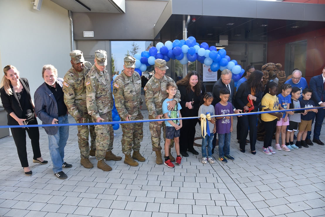 More than a half a dozen Grafenwoehr Elementary students join distinguished guests and leaders from across the military community and Department of Defense Education Activity to cut the ribbon for the new Grafenwoehr Elementary School in Grafenwoehr, Germany Sept. 12, 2023. Officials from the Department of Defense Education Activity, U.S. Army Corps of Engineers, U.S. Army Garrison Bavaria, 7th Army Training Command and more participated in the ceremony for the new school. (U.S. Army photo by Richard Puckett)