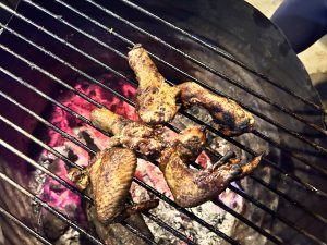 Grilling a few pieces of chicken on the barbecue.