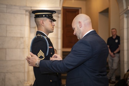 Bryan Campagna pins the Guard, Tomb of the Unknown Soldier Identification Badge onto his son, U.S. Army Staff Sgt. Isaiah Jasso-Campagna, during a ceremony in the Lower Memorial Amphitheater Chapel at Arlington National Cemetery, Arlington, Va., Jan. 11, 2024. Campagna is also a Tomb Badge holder, earning his in 2002.
