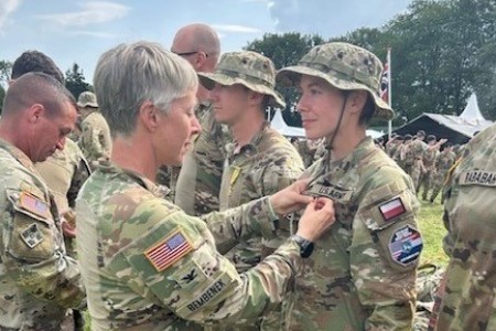 Capt. Chelsea Michta, the first person to direct commission into the U.S. Army Military Intelligence Corps, receives a medal from Col. Christina Bembenek, 66th Military Intelligence Brigade commander, upon her completion of the 100-mile Nijmegen march in 2022 in the Netherlands.