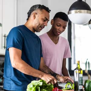 Father and teenage son cooking