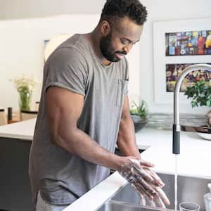 Man washing hands at the kitchen sink 