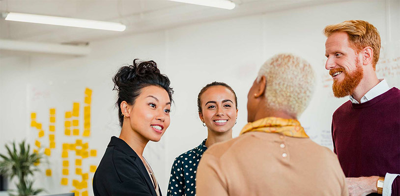 A group of professionals standing in discussion in a circle.