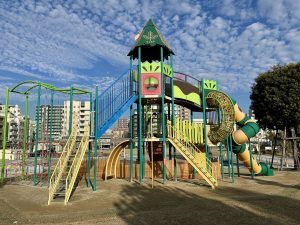 A colorful playground structure with spiral slide and stairs.
