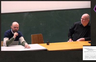 Screenshot of Krzysztof Siewicz and Bradley Kuhn sitting at a table at FOSDEM 2024