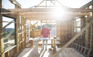 Builder working on framing a house