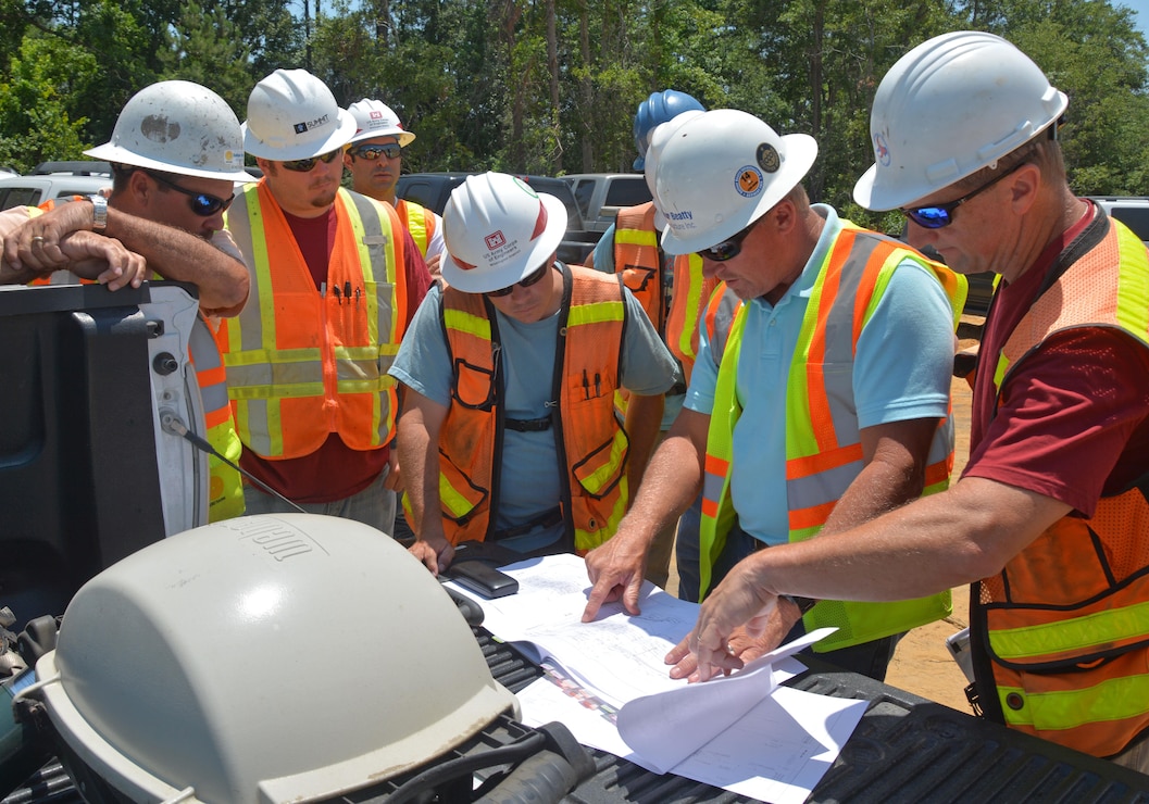 Regulatory Project Manager Brad Shaver, center, discusses the progress of construction of a highway in Brunswick County with local and state officials.  