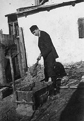 Naftali Saleschutz (Norman Salsitz) prepares cement for the foundation of a sukkah (a hut-like structure used to celebrate the Jewish holiday of Sukkot). Kolbuszowa, Poland, 1937.