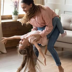 A mother and her daughter dancing on laminate floor