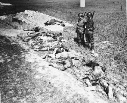 American soldiers look at the exhumed bodies of prisoners who were burned alive in a barn outside Gardelegen. Germany, April 14-18, 1945.