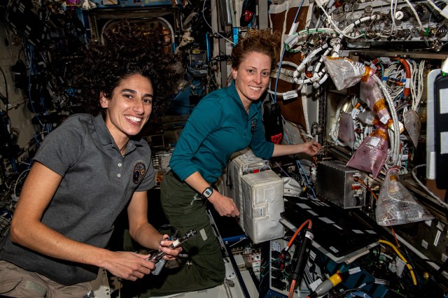 NASA astronauts (from left) Jasmin Moghbeli and Loral O'Hara, both Expedition 70 Flight Engineers, partner together removing and replacing components inside the Cold Atom Lab aboard the International Space Station. The space physics device enables observations of atoms chilled to temperatures near absolute zero allowing scientists to study fundamental behaviors and quantum characteristics not possible on Earth.