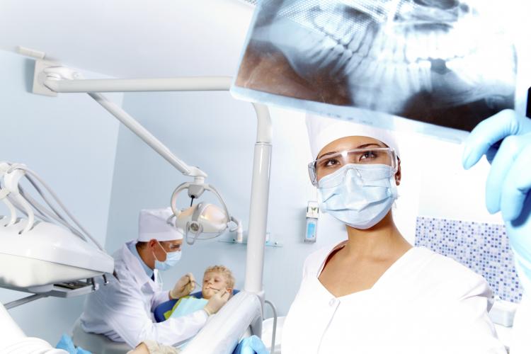 Dentist looking at tooth x-ray.