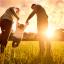 Parents playing with their young daughter in the evening sun