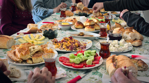 A table full of food and Turkish tea and hungry hands grabbing at it.