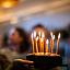 Girl with birthday cake and candles in front of blurry background