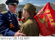 Мальчик в советской форме времен Великой Отечественной войны разговаривает с ветераном на Театральной площади в годовщину 70-летия Дня Победы в центре города Москвы, Россия (2015 год). Редакционное фото, фотограф Николай Винокуров / Фотобанк Лори