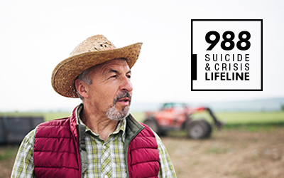 White man standing in front of a tractor