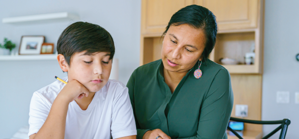 mother and son sitting at table working together