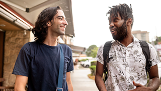 two male friends talking outside of building