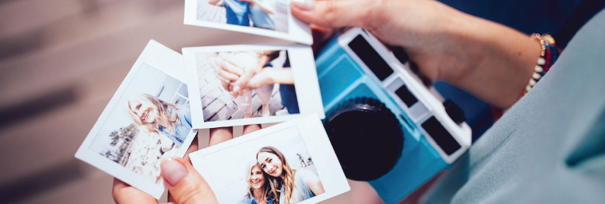 Young woman holding polaroid photos with mom