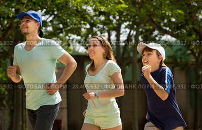 Three people running in park