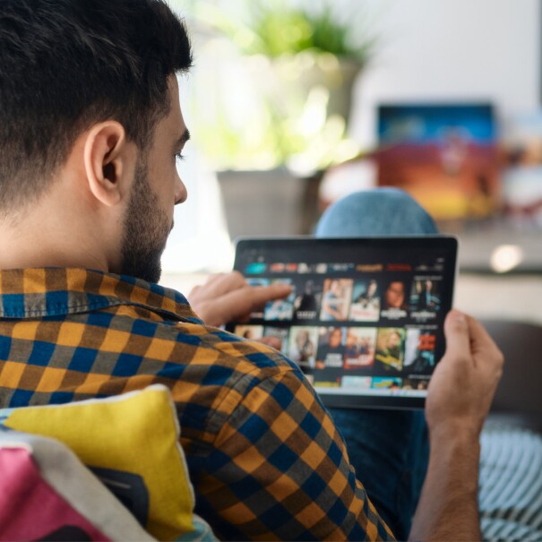 Homme sur un canapé avec une tablette pour diffuser du contenu