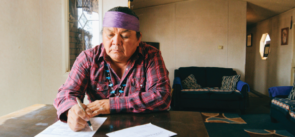 man at table writing