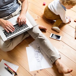 Father at home with his little son using laptop 