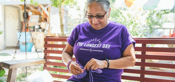 Woman knitting, wearing The Longest Day shirt