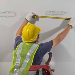 Worker fixing pipe in ceiling