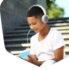 Young boy watching videos on a mobile phone outside