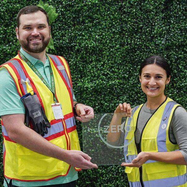 Employees in safety vests posing outside