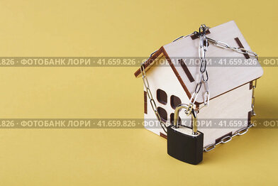 Housing arrest. Castle house. Small toy house and a chain with a lock.