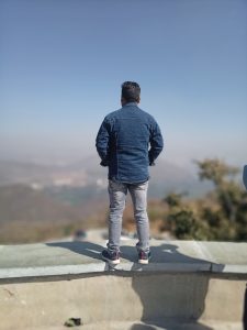 The back of a man looking out over a valley
