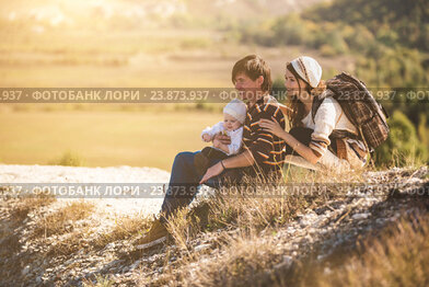 Молодые родители с ребенком в горах