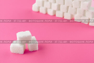 Cubes of sugar on a pink background. Empty space for copying text