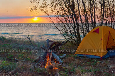 Camping by the sea, tourist tent at sunset